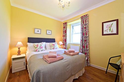 a bedroom with a bed with two pillows on it at Fordel Cottage in Dalkeith