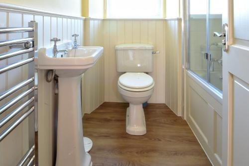 a bathroom with a toilet and a sink at Fordel Cottage in Dalkeith