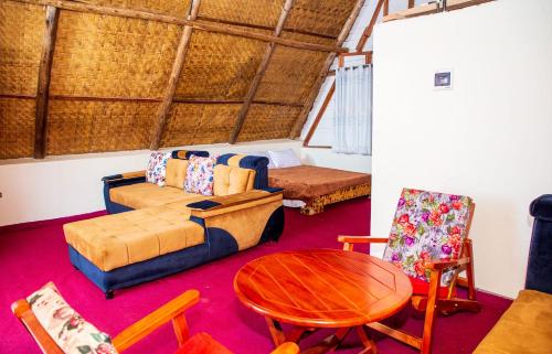 een woonkamer met een bank en een tafel en stoelen bij Bugoma Sand Beach and Resort Hotel in Beta