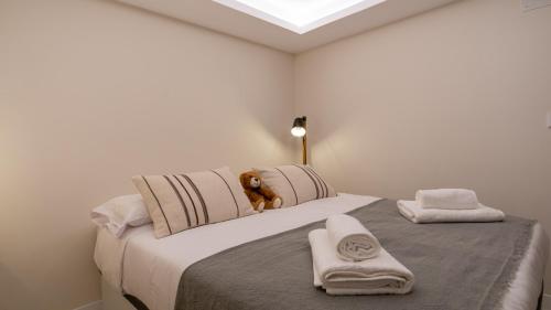 un dormitorio con una cama con un osito de peluche sentado en ella en Osito Hub - Poeta Durán en Valencia