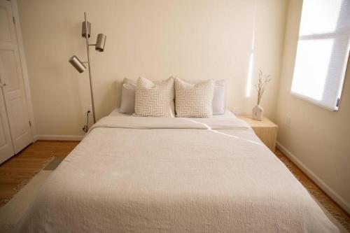 1 cama blanca grande en una habitación con ventana en Entire rowhouse in Capitol Hill with free parking, en Washington