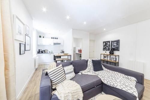 un salon avec un canapé bleu et une cuisine dans l'établissement Le Ferry, à Laval