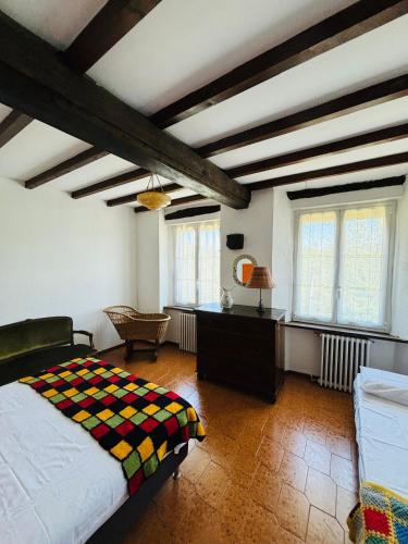 a bedroom with a bed and a desk and windows at A casa di Mirna in Borghetto Di Borbera