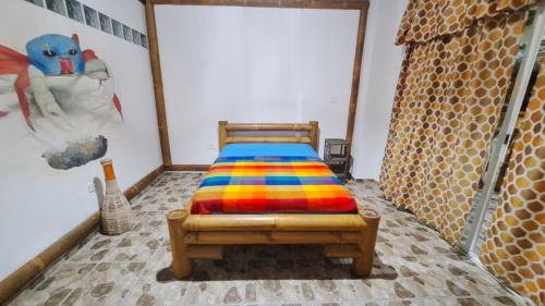a bedroom with a bed with a colorful blanket on it at Casa Gaia: Un Paraiso in Mompiche