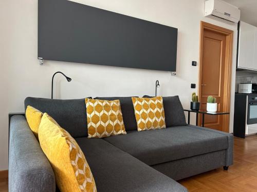 uma sala de estar com um sofá com almofadas amarelas em Miro Home II em Roma