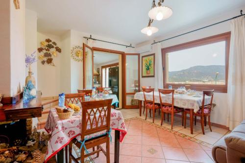 uma sala de jantar com uma mesa e cadeiras e uma janela em B&B Ametista em Villasimius