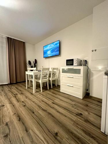 E&K Apartment II في دوسلدورف: غرفة معيشة مع طاولة وتلفزيون على الحائط