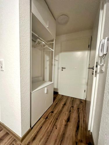 E&K Apartment II في دوسلدورف: غرفة فارغة مع خزانة وأرضية خشبية