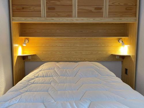 - une chambre avec un lit blanc éclairé dans l'établissement T1 confortable avec balcon et ascenseur à Balaruc-les-Bains - FR-1-553-181, à Balaruc-les-Bains