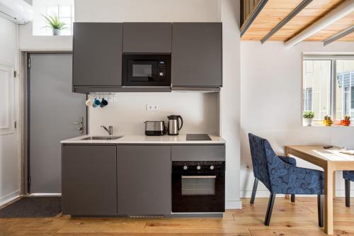 a kitchen with a sink and a stove top oven at Studio Nest - Near the train to Lisbon & Sintra in Algueirão - Mem Martins