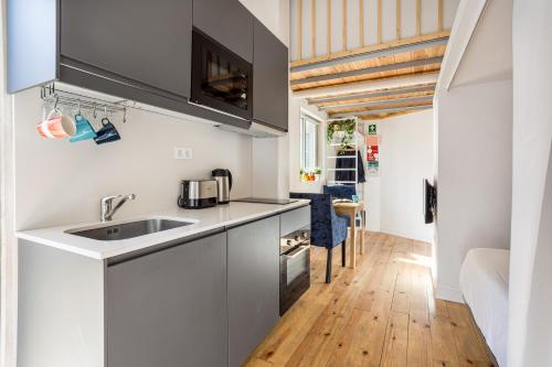 a kitchen with white cabinets and a sink at Studio Nest - Near the train to Lisbon & Sintra in Algueirão - Mem Martins