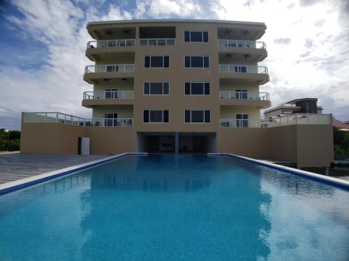 un hotel con piscina frente a un edificio en Coconuts Caribe en San Pedro