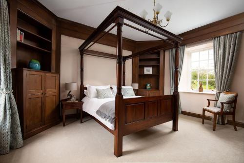 a bedroom with a canopy bed and a window at Fairnington East Wing in Kelso