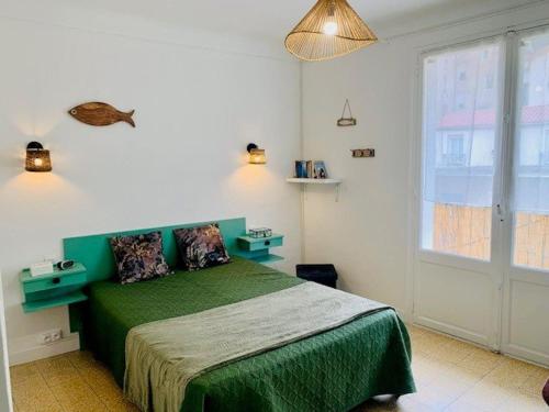 een slaapkamer met een groen bed en een raam bij Appartement Amélie-les-Bains-Palalda, 4 pièces, 4 personnes - FR-1-703-104 in Amélie-les-Bains-Palalda