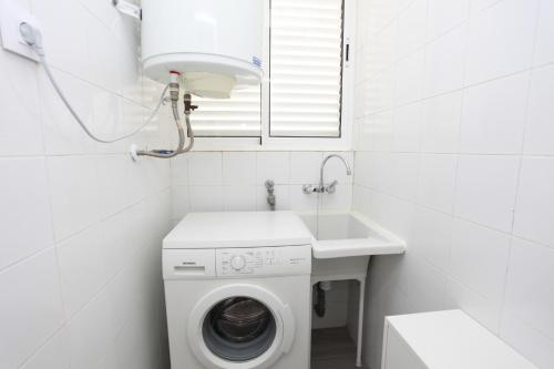 a white bathroom with a washing machine and a sink at Dúplex Villas Romanas con vistas espectaculares in Cartagena