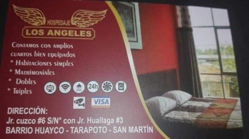 un cartel en la ventana de una habitación con sofá en Hostal Los Angeles, en Tarapoto