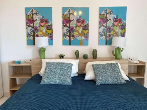 - une chambre avec un lit orné de 3 peintures murales dans l'établissement Appartement T2 avec terrasse, parking et WIFI - FR-1-553-203, à Balaruc-les-Bains