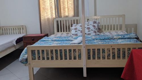 een slaapkamer met een houten stapelbed met een blauw dekbed bij JACARANDA HOMESTAY in Moshi