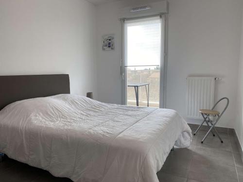 a bedroom with a bed and a chair and a window at Appartement T2 avec balcon, parking privé, wifi - Balaruc-les-Bains - FR-1-553-204 in Balaruc-les-Bains