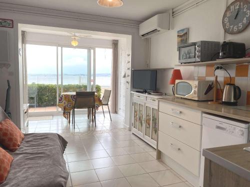 - une cuisine avec une table et une vue sur l'océan dans l'établissement Charmant T1 avec climatisation, WIFI, parking à Balaruc-les-Bains - FR-1-553-218, à Balaruc-les-Bains