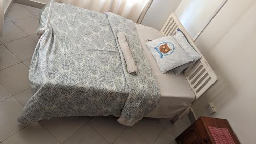 een bed met een witte deken en kussens erop bij JACARANDA HOMESTAY in Moshi