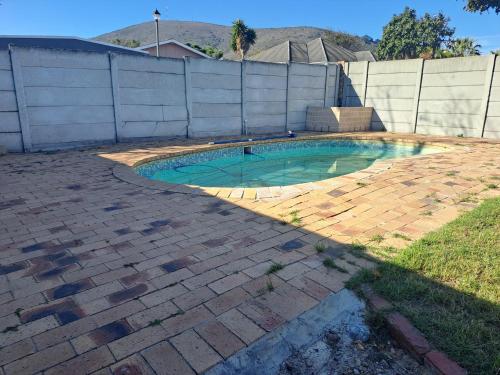 una pequeña piscina en un patio de ladrillo en Excel North Accommodation, en Ciudad del Cabo