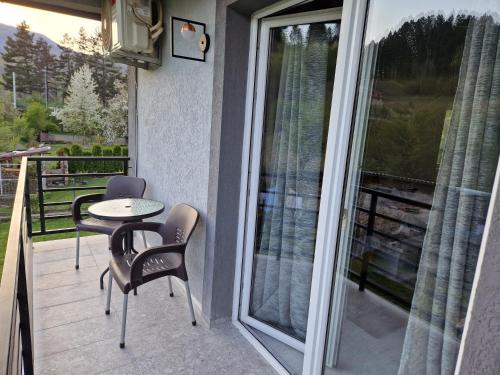 a patio with a table and chairs on a balcony at Apartman Irvas Kolasin in Kolašin