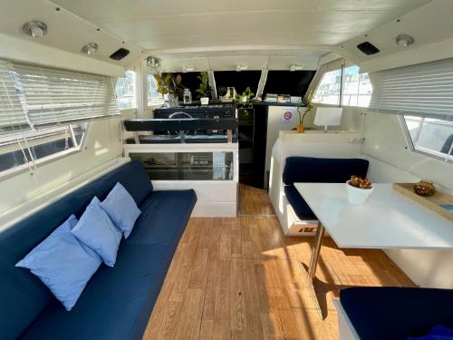 uma sala de estar com um sofá azul e uma mesa em Barco amplio con 2 camarotes / Comfy Boat with 2 bedrooms - Barcelona em Barcelona