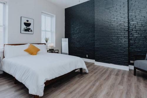 a bedroom with a bed and a brick wall at Spacious 8BR-4BA Group HQ Patio&Games Soulard in Soulard