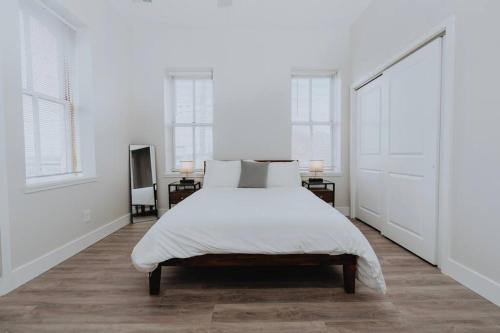 a white bedroom with a large bed and windows at Spacious 8BR-4BA Group HQ Patio&Games Soulard in Soulard