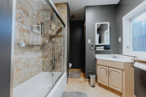 uma casa de banho com um chuveiro, uma banheira e um lavatório. em Urban Studio WFH Setup & Patio Soulard em Soulard