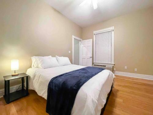 een slaapkamer met een bed en een tafel met een lamp bij Modern 1BR-1BA Monthly Rental The Hill in Tower Grove