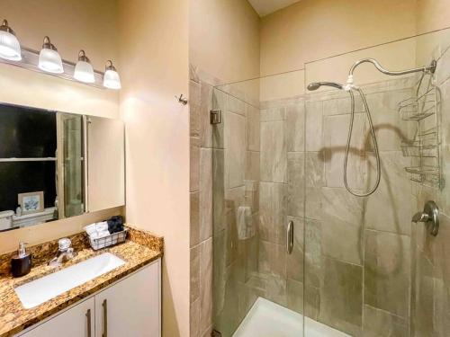 a bathroom with a shower and a sink and a mirror at Modern 1BR-1BA Monthly Rental The Hill in Tower Grove