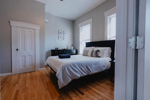 1 dormitorio con 1 cama grande y suelo de madera en Chic 1BR Balcony & Laundry Soulard, en Soulard