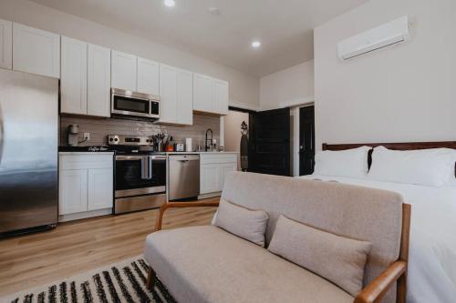 a bedroom with a bed and a kitchen with a couch at Chic Studio Walk to SMM SLU Hospital Grand in Tower Grove