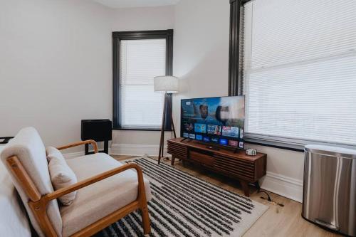 a living room with a tv and a couch and a chair at Chic Studio Walk to SMM SLU Hospital Grand in Tower Grove