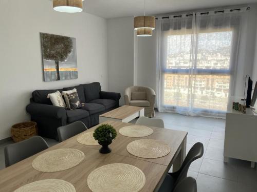 ein Wohnzimmer mit einem Tisch und einem Sofa in der Unterkunft piso recinto ferial en teatinos in Málaga