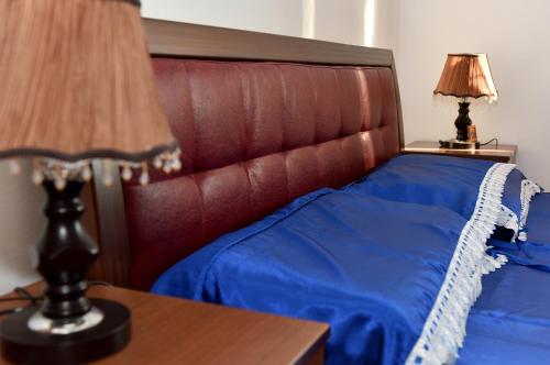 a bedroom with a bed with a red headboard at Vila Merkuri in Vlorë