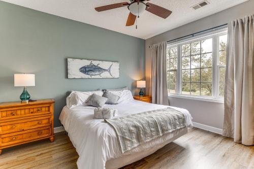 a bedroom with a bed with a ceiling fan and a window at North Myrtle Beach Condo Rental with Pool Access! in North Myrtle Beach
