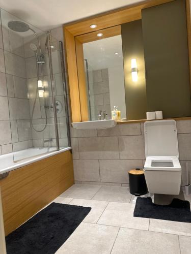 ein Bad mit einer Dusche, einem WC und einem Waschbecken in der Unterkunft Simply lux apartment in London