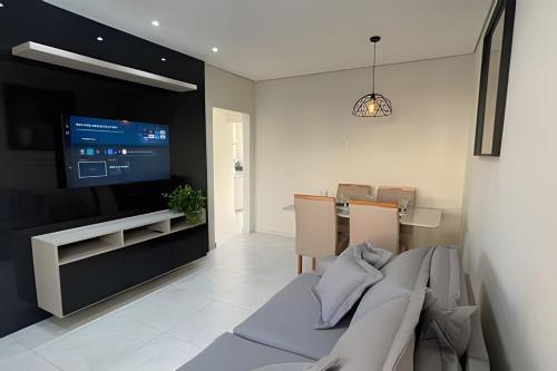a living room with a television and a dining room at Casa Bela Vista no centro São Roque in São Roque