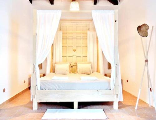 un letto bianco a baldacchino in una stanza di Casa colonial en el centro de San Cristobal de las casas a San Cristóbal de Las Casas