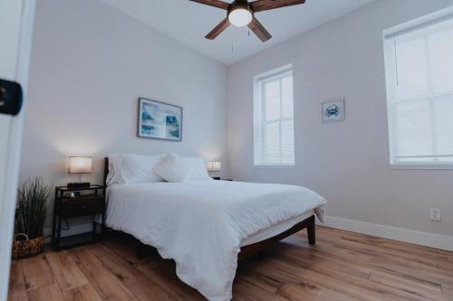 - une chambre blanche avec un lit et un ventilateur de plafond dans l'établissement Spacious 2BR-2BA Patio & Games Soulard, à Soulard