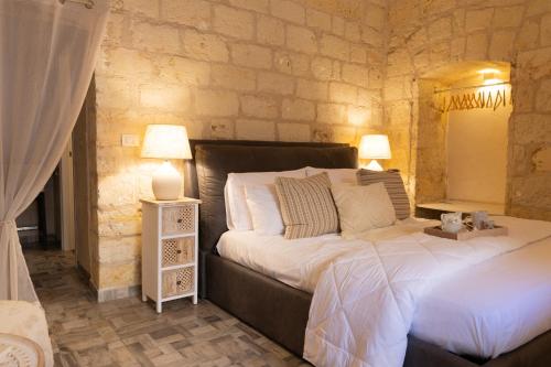 a bedroom with a large bed and two lamps at Damà Luxury Room con Jacuzzi in Bisceglie