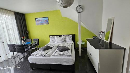 een slaapkamer met een bed met een gele muur bij Sewdien’s Apartment Maashaven in Rotterdam
