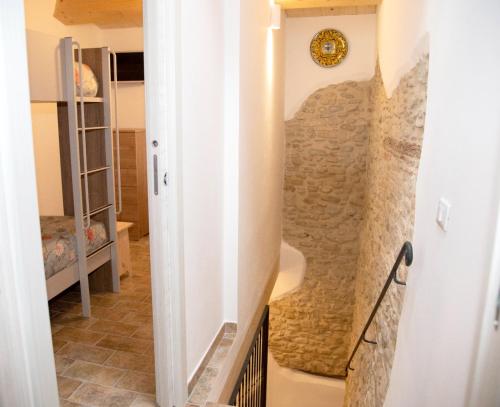 a hallway with a stone wall and a clock on the wall at LA BRAVERIA in Urbania