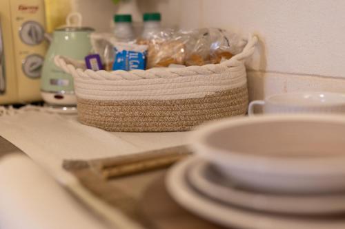 a basket sitting on top of a counter with plates at Damà Luxury Room con Jacuzzi in Bisceglie