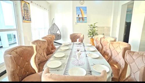 a table with chairs and a table with plates on it at ST Beach Villa in Kibweni