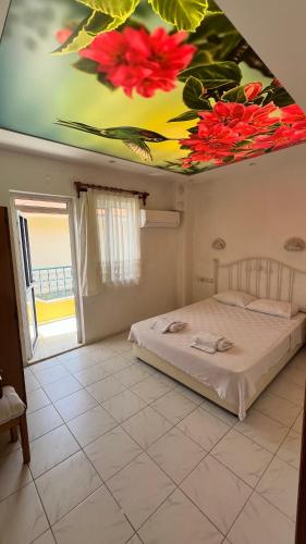 a bedroom with a bed with flowers painted on the ceiling at Kayalı apart hotel in Ortaca