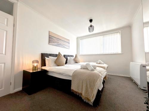 Un dormitorio con una cama grande y una ventana en Contemporary and Cosy Birmingham Apartment- Free Parking & Wi-FI en Birmingham
